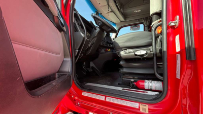 Kenworth T680 cab interior view from doorway highlighting driver seat and dashboard.