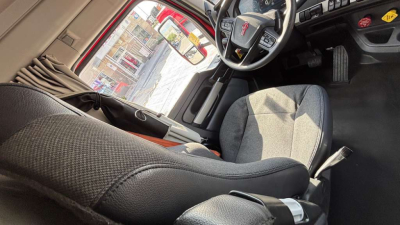 Kenworth T680 cab interior showing driver seat and steering wheel with dashboard view