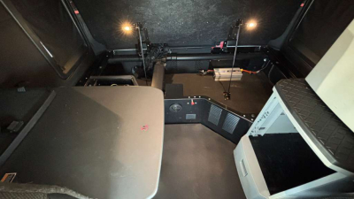 Kenworth T680 interior cab area showing sleeper bunk and dashboard controls with overhead storage.