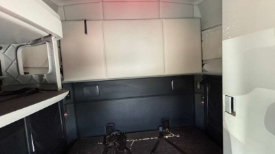 Truck sleeper cab interior showing storage cabinets and bed area with white and gray panels.