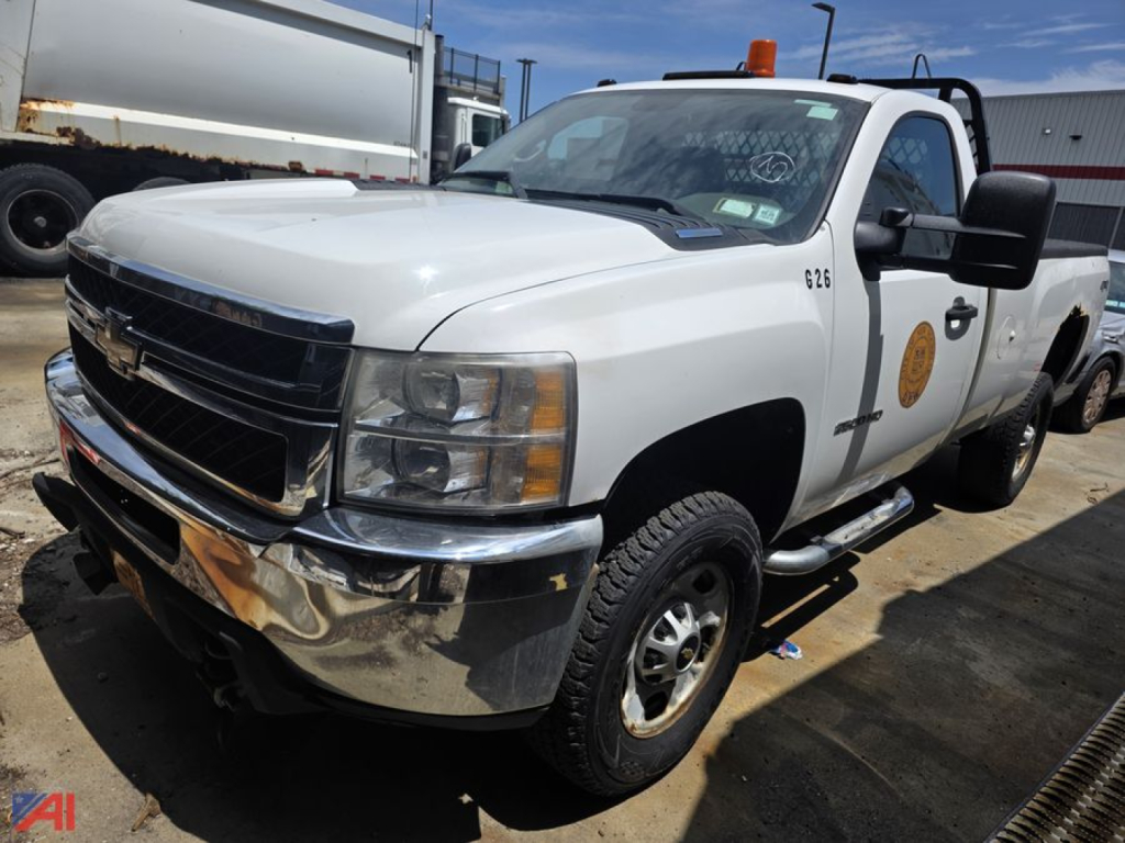 Chevrolet Silverado 2500HD pickup truck in white, front-left view, with chrome bumper and orange beacon on cab.