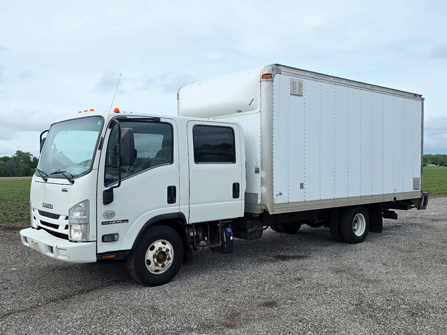 Isuzu NPR 2018 box truck side and front view showing cargo box and cab with white exterior.
