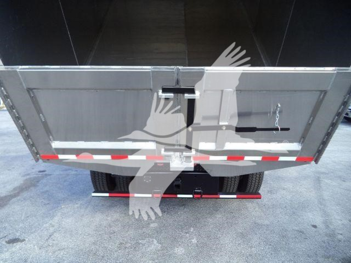Rear view of a truck bed on a 2019 International 4300 dump truck showing the tailgate and rear chassis with red-and-white reflective stripes.