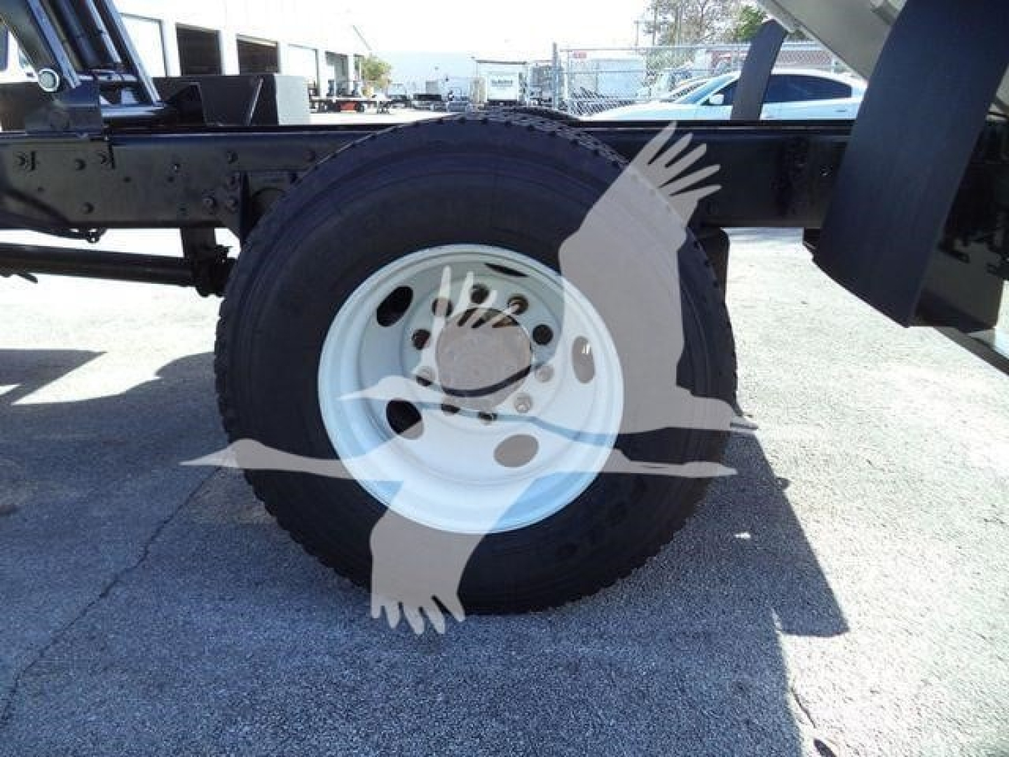 Wheel and chassis of a used 2019 International 4300 truck with white steel rim and black tire, chassis frame visible.