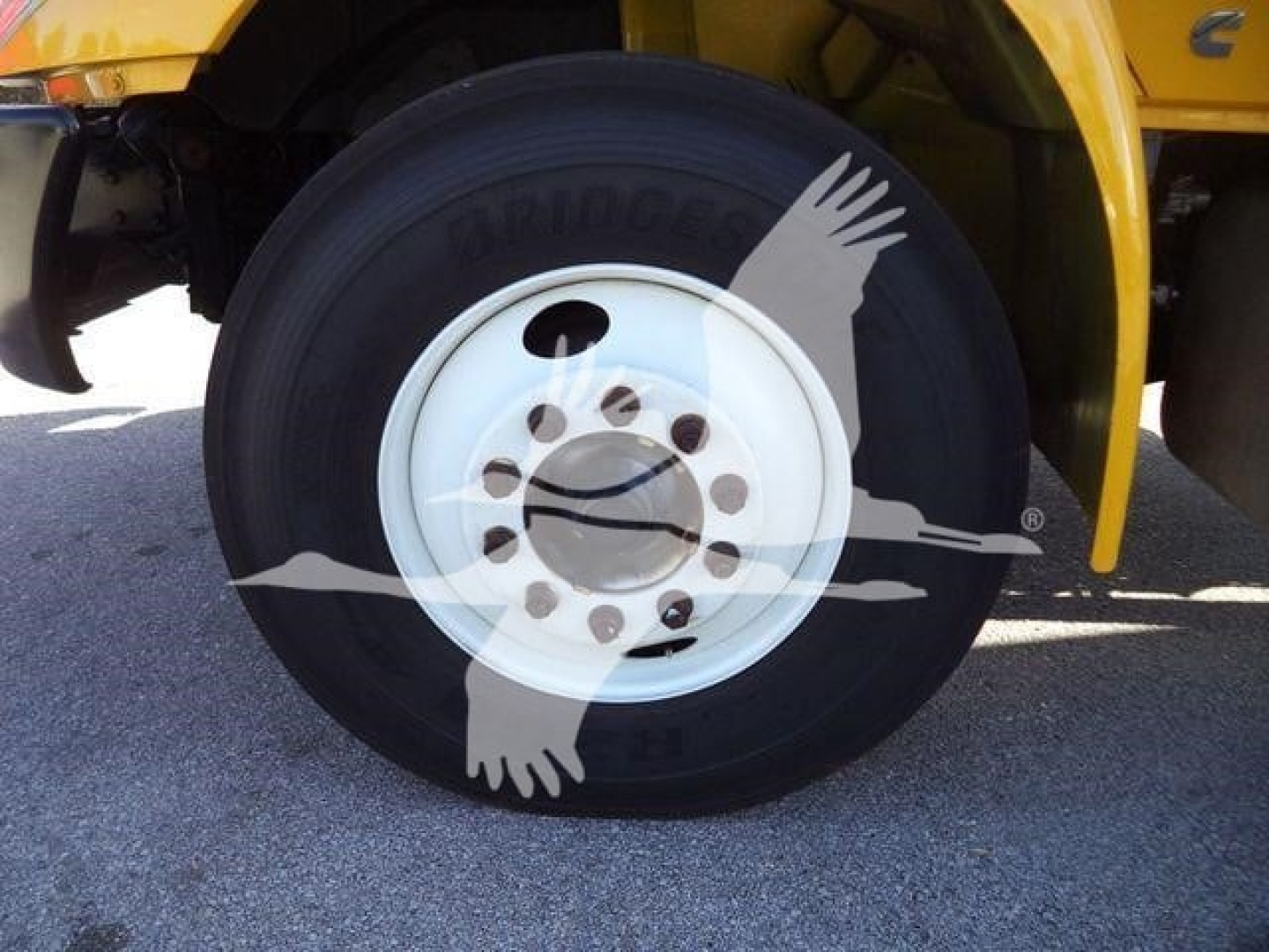 Truck wheel and tire on a 2019 International 4300 chipper body, showing Bridgestone tire and white steel wheel with lug nuts.