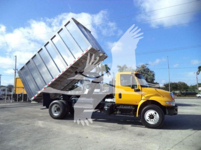 2019 International 4300 dump truck with yellow cab and silver dump bed raised, in a parking lot.