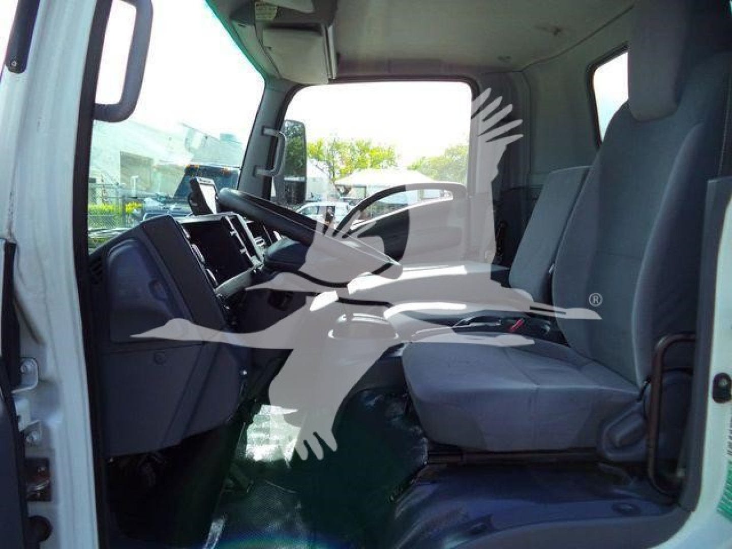 Isuzu NPR/Nrr truck interior cabin showing driver seat and front dashboard with steering wheel and passenger seat.