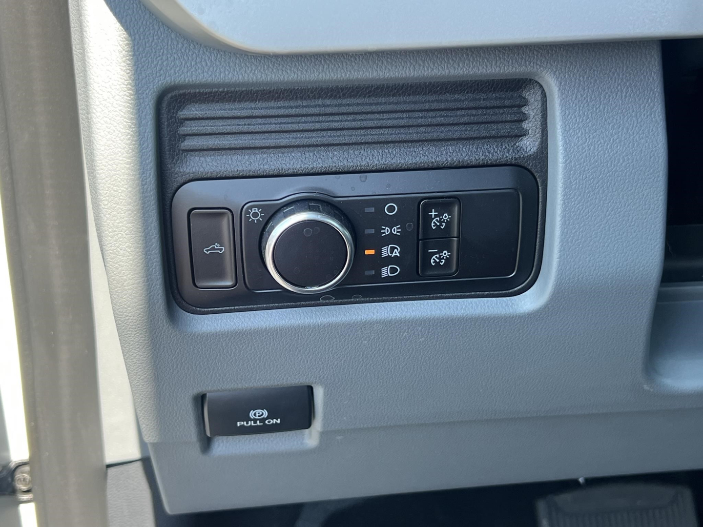 Ford F-450 cab and chassis dashboard controls showing headlight switch and auxiliary panel.