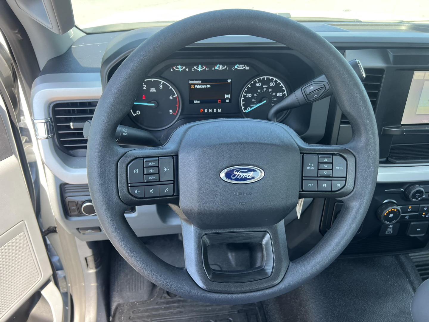 Ford F-450 cab and chassis interior showing steering wheel with Ford logo and instrument cluster.