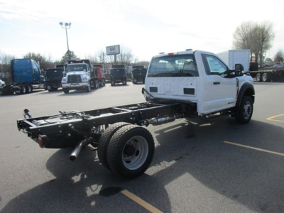 Ford F-450 cab and chassis truck with white cab, exposed chassis frame, single rear axle, in inventory lot.