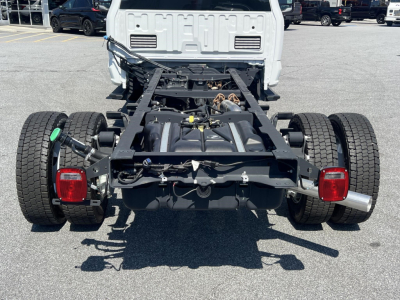 Chassis cab rear view of a 2026 Ford F-450 truck showing frame, dual rear axles, exhaust, taillights, and hitch area.