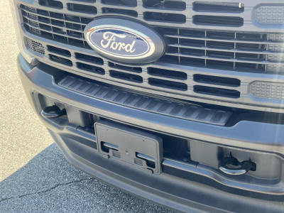 Front view of a Ford F-Series cab and chassis showing Ford emblem and front bumper area.