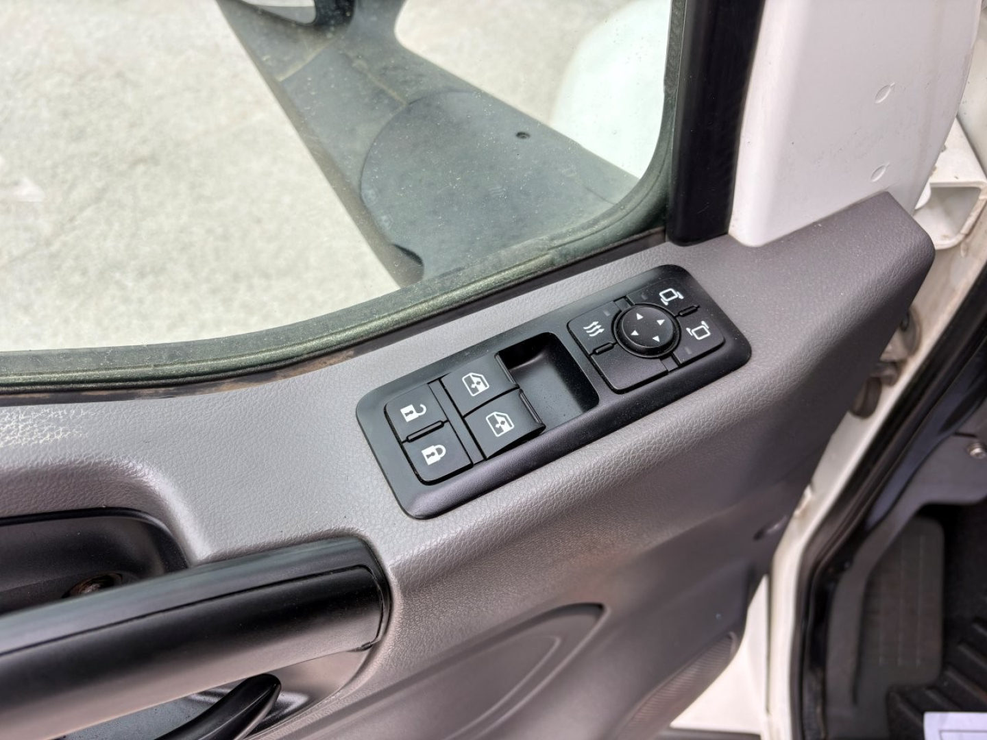 Interior of a 2019 International LT truck door panel showing window controls and mirror joystick.