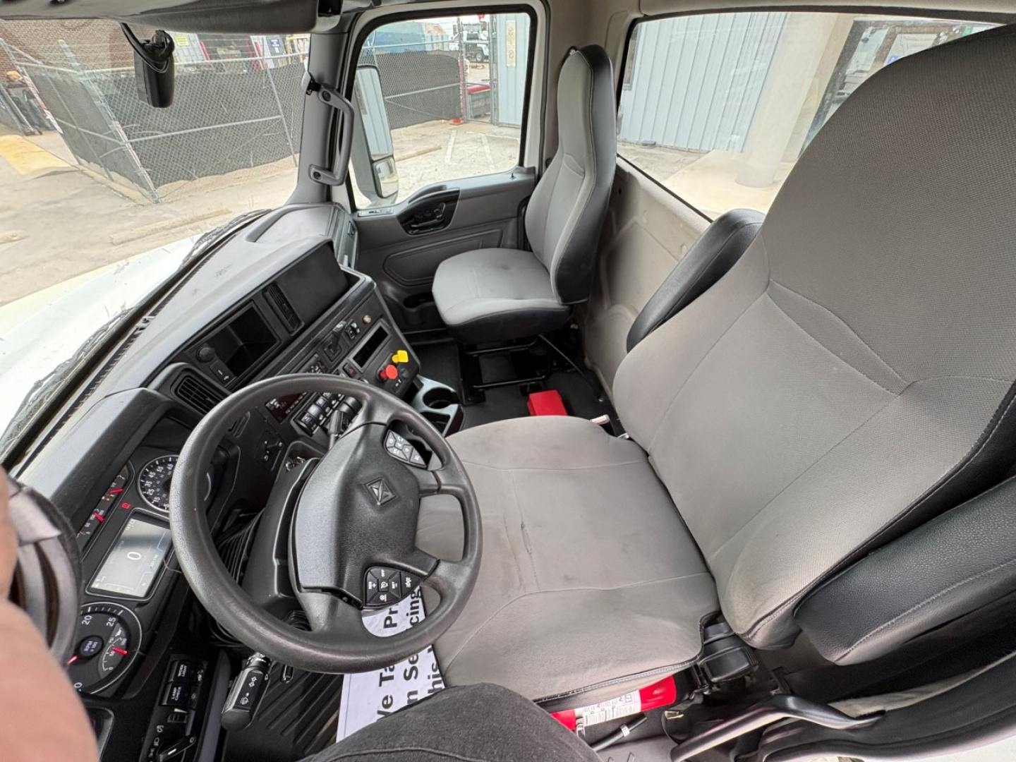 Interior of a 2019 International LT truck cab showing steering wheel, driver's seat, dashboard, and passenger seat.