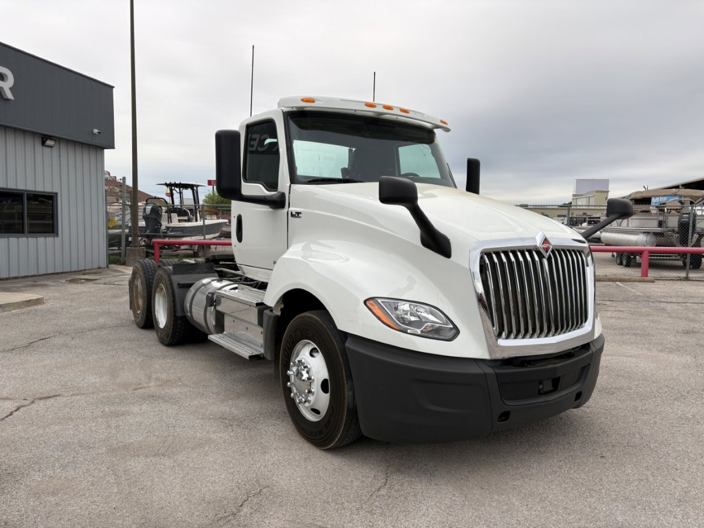 International LT truck cab and chassis in white, front three-quarter view showing grille, headlights, side mirrors, and fuel tanks.