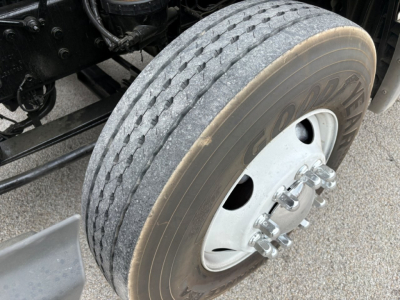 Truck axle close-up showing front dual tires and wheel with lug nuts on a 2019 International LT conventional daycab