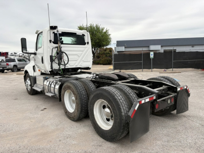 Truck chassis and cab of a 2019 International LT daycab showing rear dual axle with fifth wheel and mud flaps