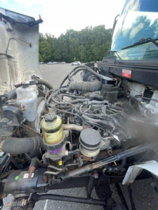 Truck engine bay of a 2019 Hino 268 with visible fuel filter, air intake, hoses, and hydraulic lines in view.