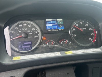 Dashboard of a 2019 Hino 268 showing gauges: speedometer 0-105 mph with km/h inner, tachometer up to 35? RPM, digital display with time and date, warning icons, fuel/temp gauges.