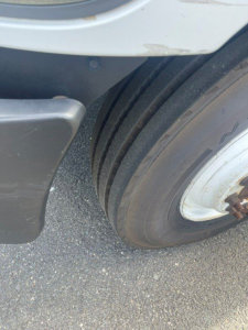 Hino 268 truck wheel and fender area showing dual rear tires and wheel well.