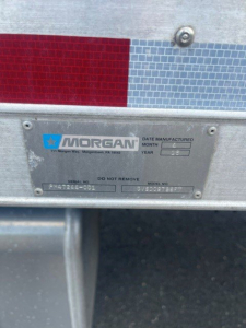 Box truck rear plaque showing MORGAN plate with serial numbers and Do Not Remove text.
