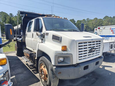 Dump truck cab in-service showing front grille and wheel wells with Chevrolet emblem, heavy-duty bumper, and side mirrors.