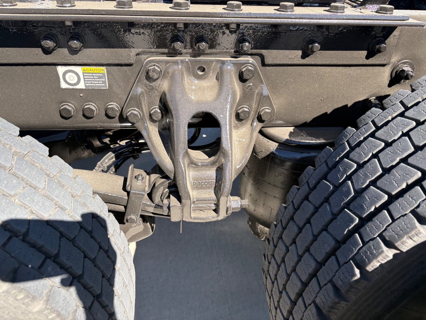 Kenworth truck rear view showing fifth wheel hitch and dual rear axles with tires, undercarriage components visible.