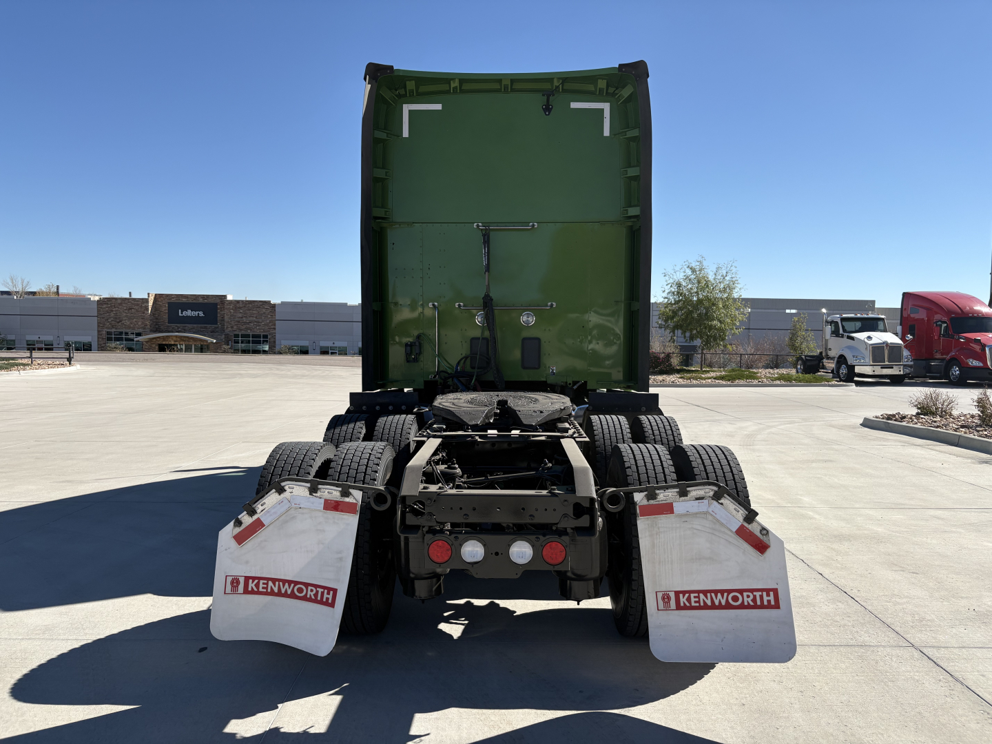 Kenworth T680 rear view showing fifth wheel, dual rear axles, and mud flaps with Kenworth logo.