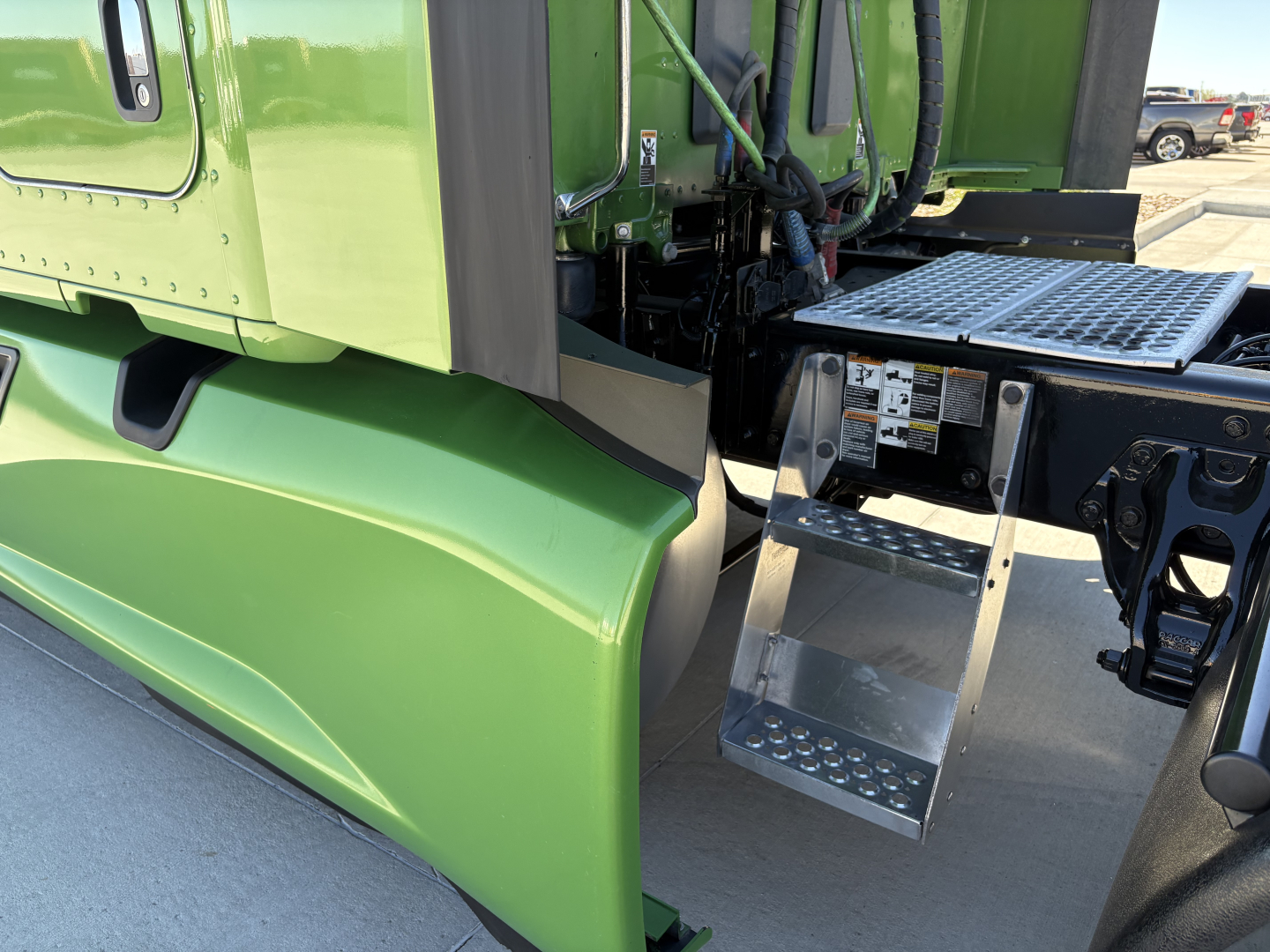 Kenworth T680 cab and green exterior with side step and entry ladder visible.