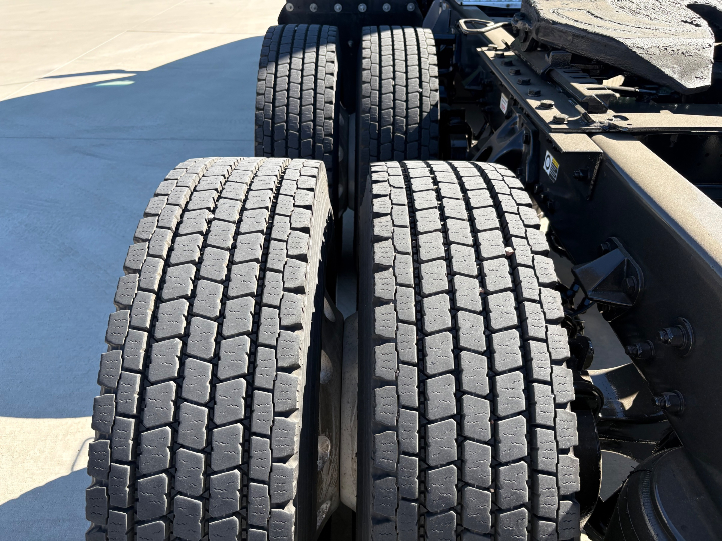 Truck rear dual tires on Kenworth T680 chassis showing tread pattern and frame components.