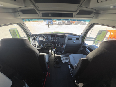 Kenworth T680 interior cab view with dashboard, steering wheel, and front seats; top overhead panels and sun visors visible.