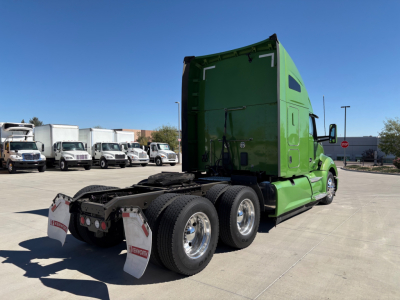 Kenworth T680 tractor in green, rear view showing fifth wheel, dual rear tires, mud flaps, and exterior decals.