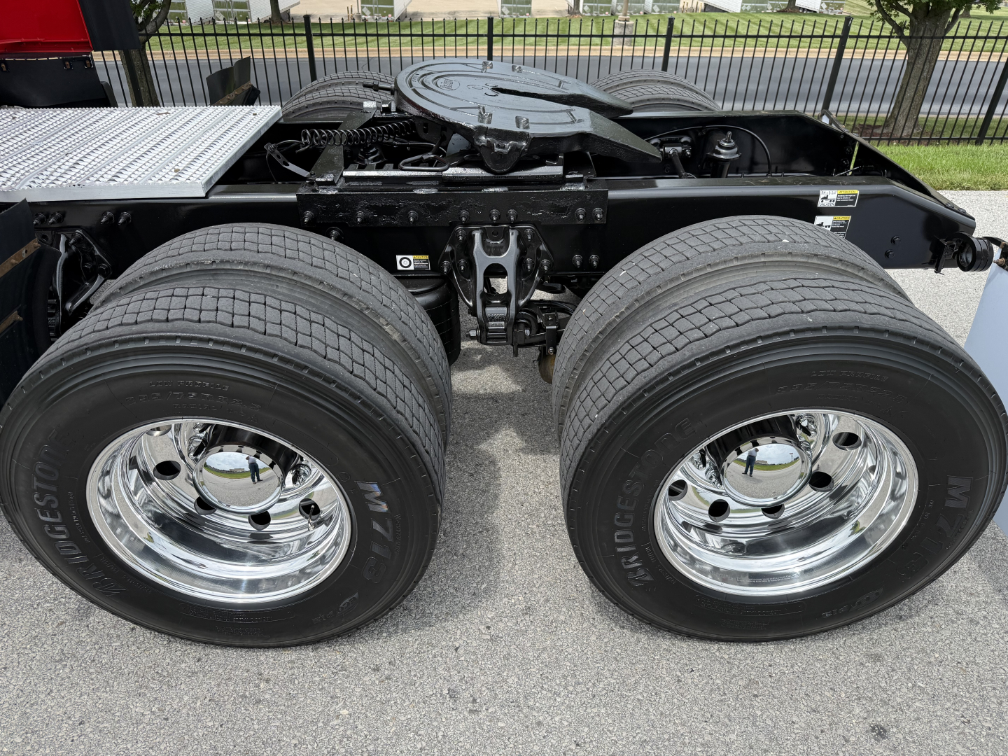 Peterbilt 579 truck chassis showing dual rear axles and wheels with chrome rims and tires.