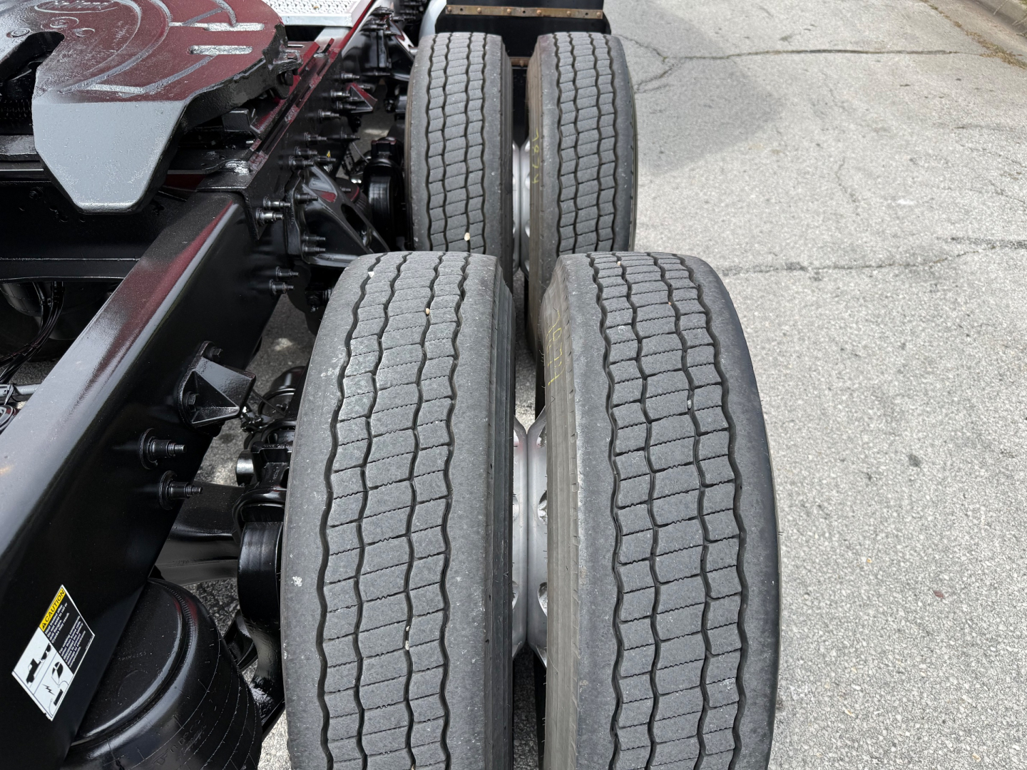 Dual rear wheels on Peterbilt truck chassis with visible suspension components and tires.