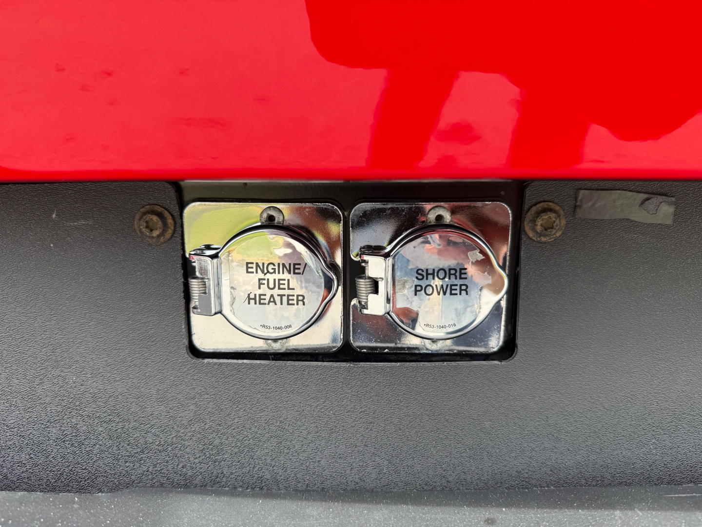 Peterbilt 579 engine bay area showing two chrome fuel heater caps labeled Engine Fuel Heater and Shore Power.