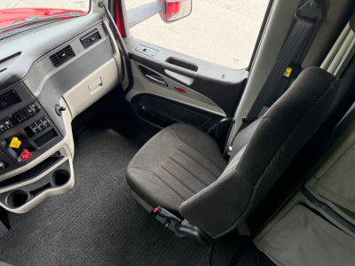 Peterbilt 579 truck cab interior showing driver seat, dashboard with controls, and door panel.