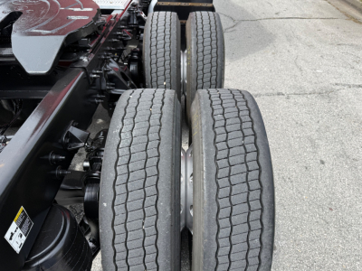Dual rear wheels on Peterbilt truck chassis with visible suspension components and tires.