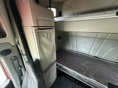 Peterbilt 579 sleeper cab interior showing bunk bed with mattress and storage compartments.