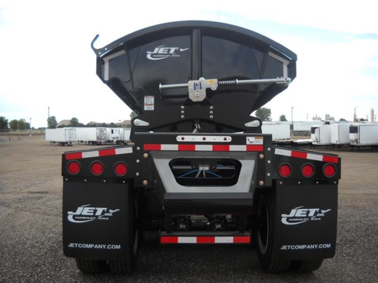 Jet Tri Axle Side Dump trailer rear view showing hydraulic hoist and mud flaps with Jet logos