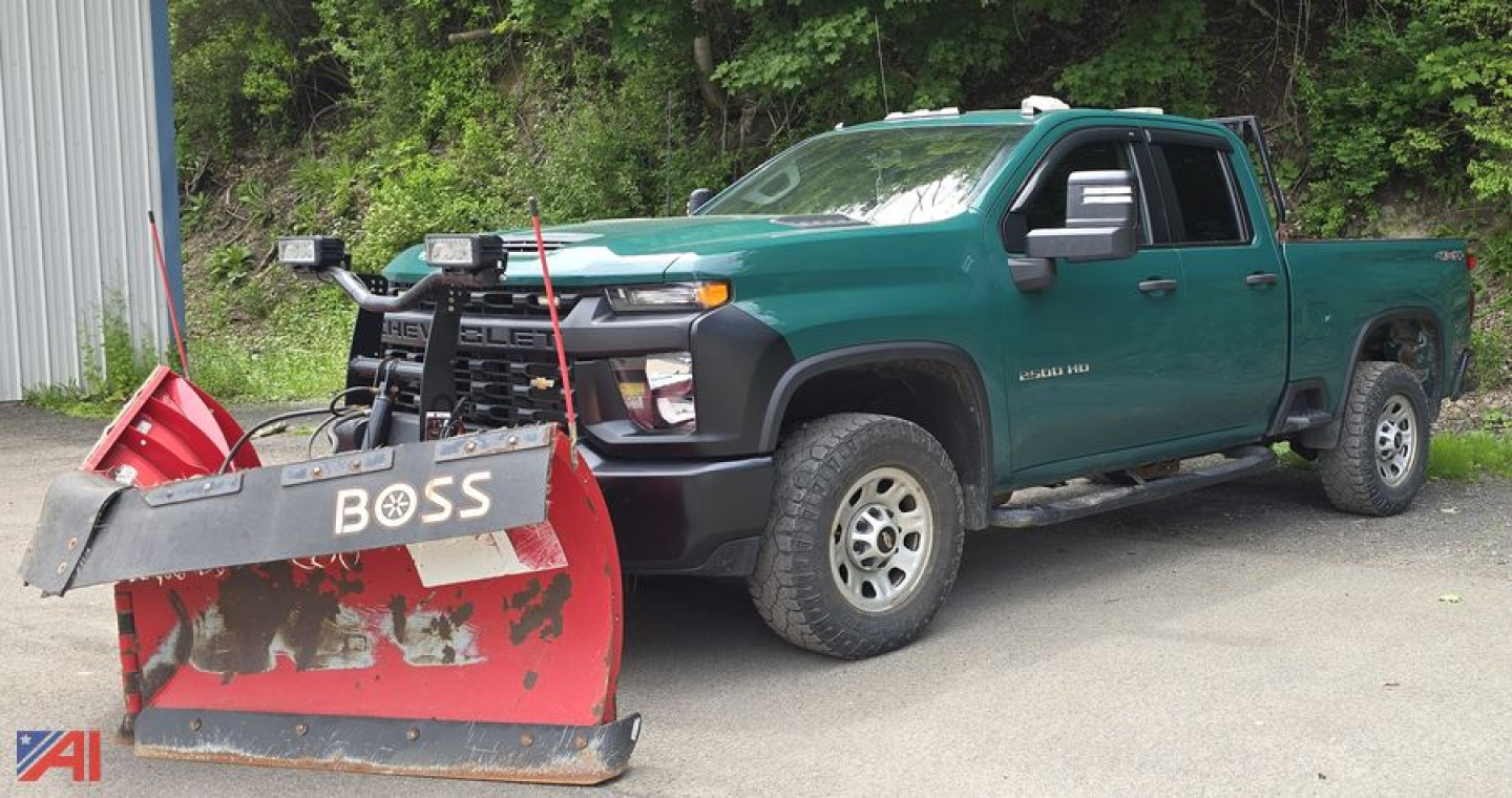Green 2023 Chevrolet Silverado 2500HD Crew Cab pickup with snow plow attached, front grille guard, large tires, side step, in-service condition.