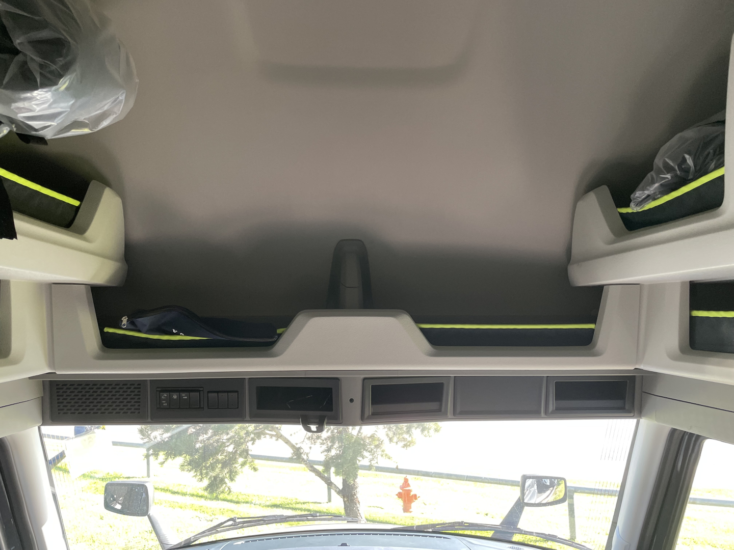 Cab interior top view of a new Volvo VNL truck showing overhead storage compartments and dash controls.
