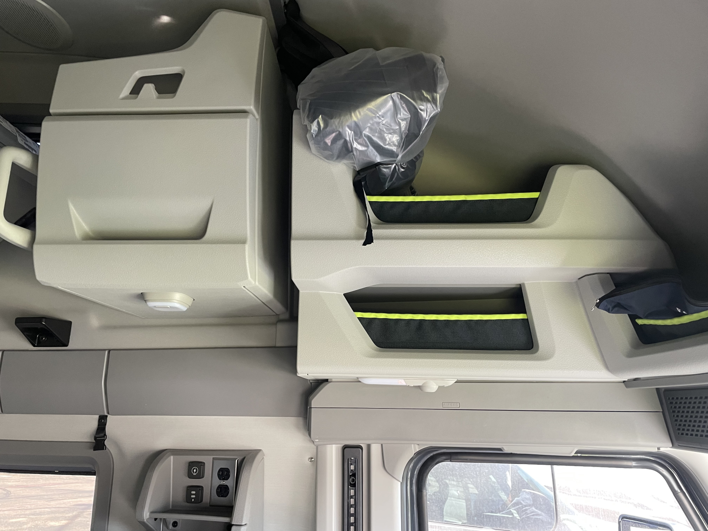 Cabin interior of a new 2026 Volvo VNL64T660 showing overhead storage compartments and sleeper bunk with light gray finish.