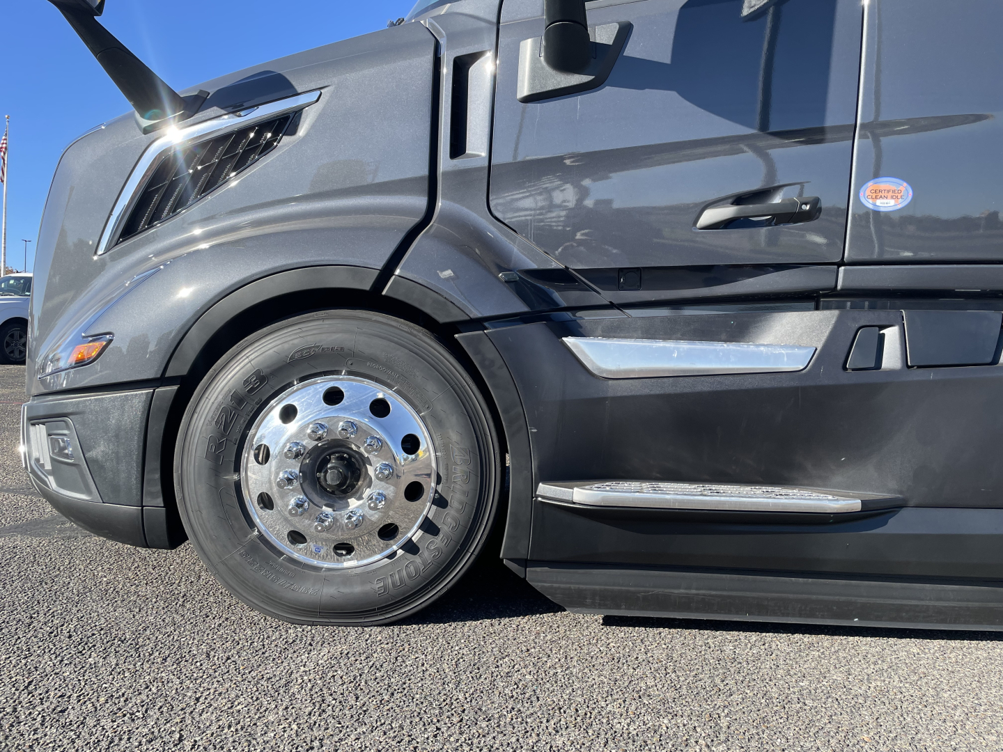 Volvo VNL64T660 truck front wheel and lower cab view with chrome wheel accents and sleek body lines.