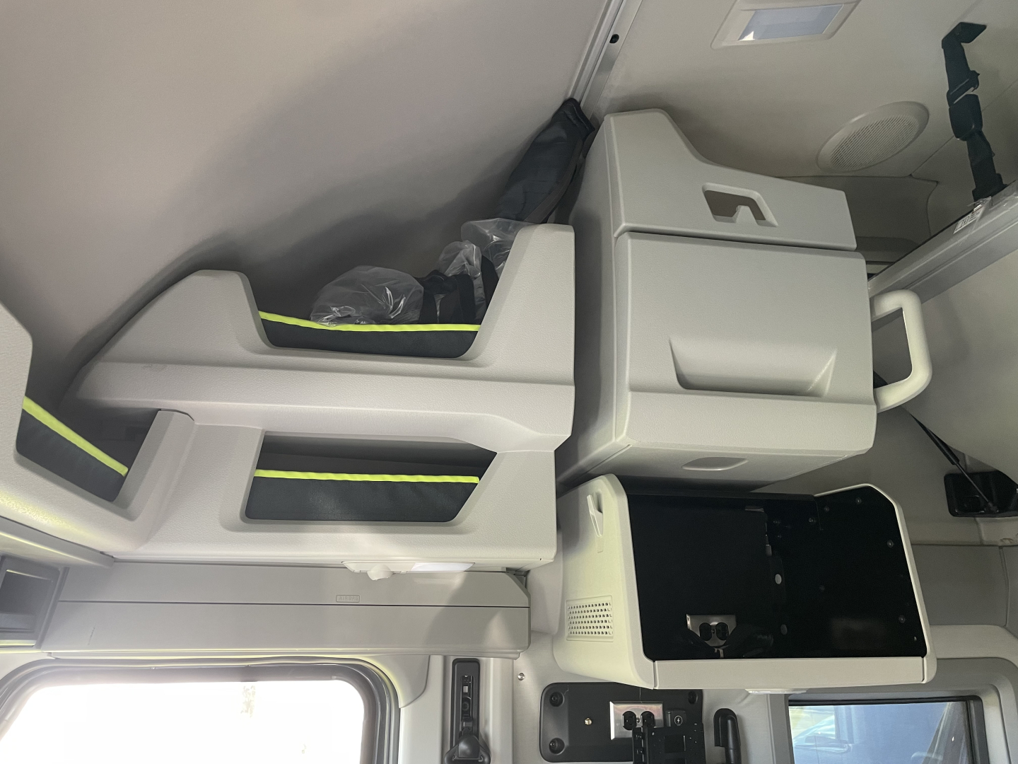 Volvo VNL64T660 interior cab area showing sleeper seat and storage compartments with light gray panels.