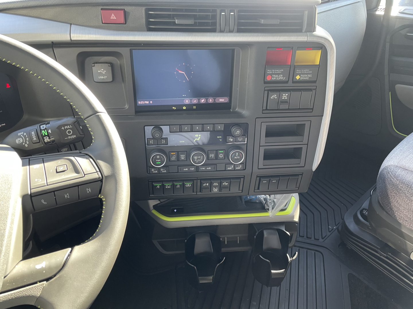 Volvo VNL64T660 interior dashboard showing center touchscreen, climate controls, and switch panels.