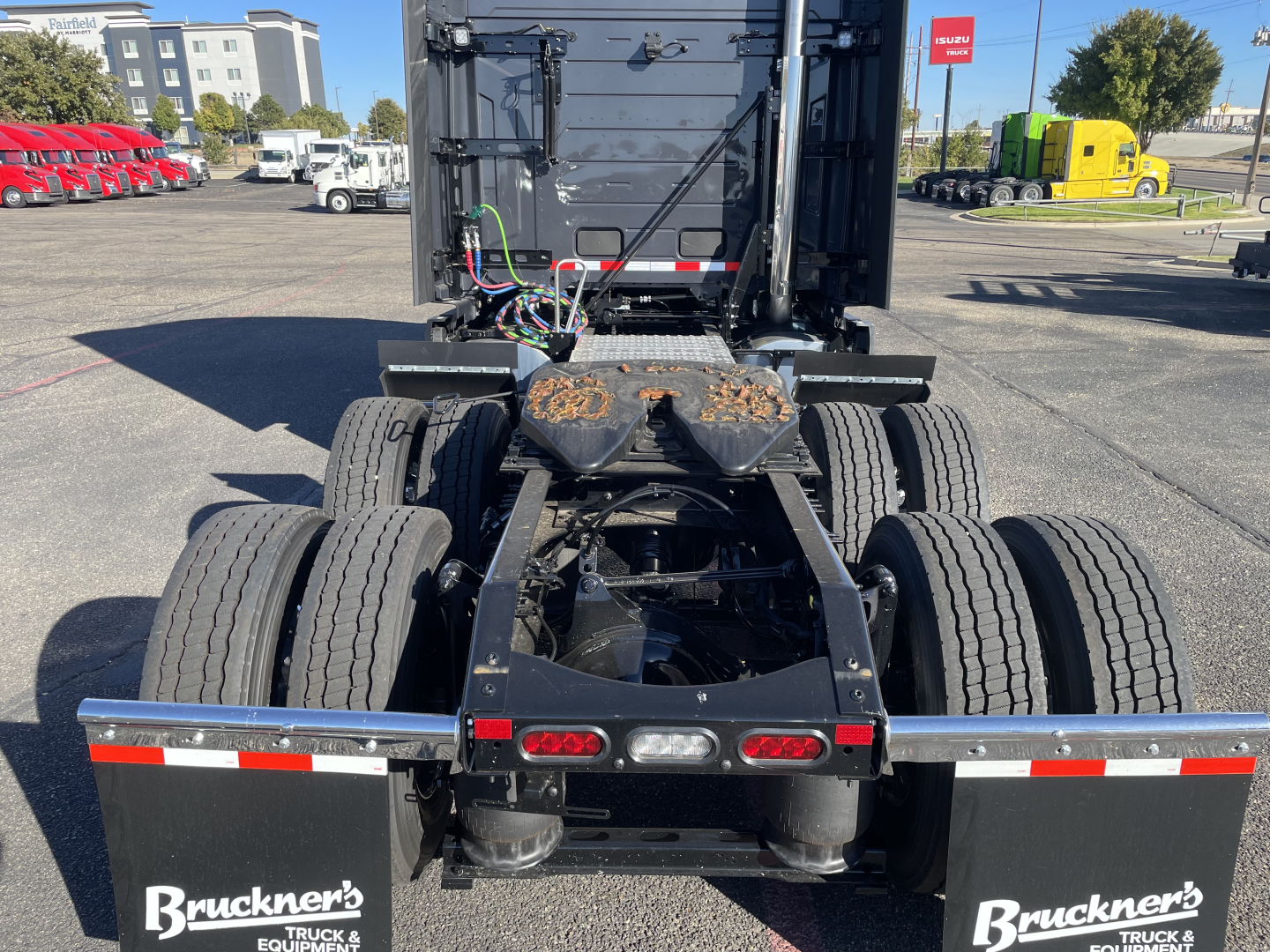 Volvo VNL64T660 tractor rear view showing fifth-wheel mounting, dual rear axles with six tires, wiring harness, and rear lights.