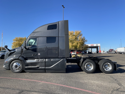 Volvo VNL64T660 cab in profile view showing sleeper cab and rear tandem axles, black/gray paint.