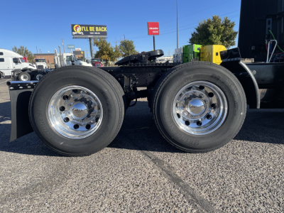 [Component] Dual rear axles with chrome wheels and tires on Volvo VNL64T660 trucks chassis showing suspension, fuel lines, and frame.