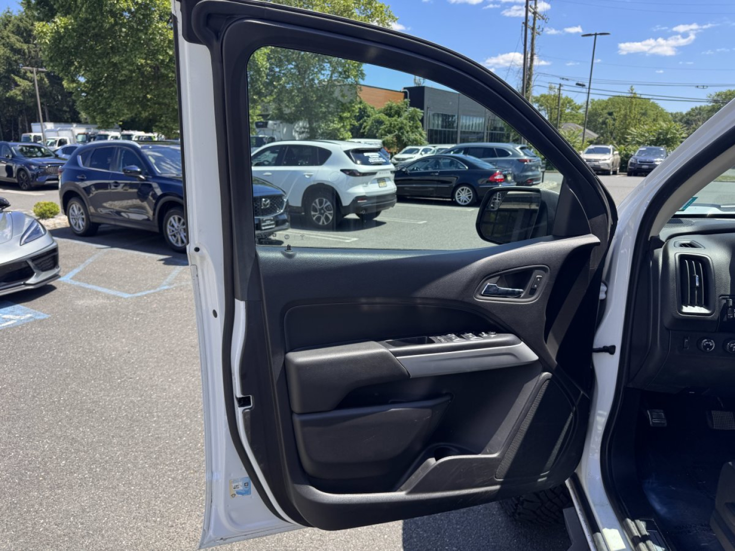 Interior of a 2018 Chevrolet Colorado front driver door open showing power window controls and door panel.