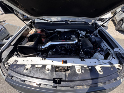 Engine bay of a 2018 Chevrolet Colorado showing intake pipe and engine components under open hood.